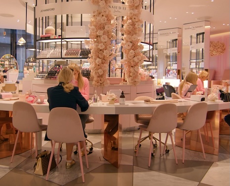 Boutique rénovée avec murs, plafonds et mobilier blancs, éléments en verre et touches de couleurs primaires